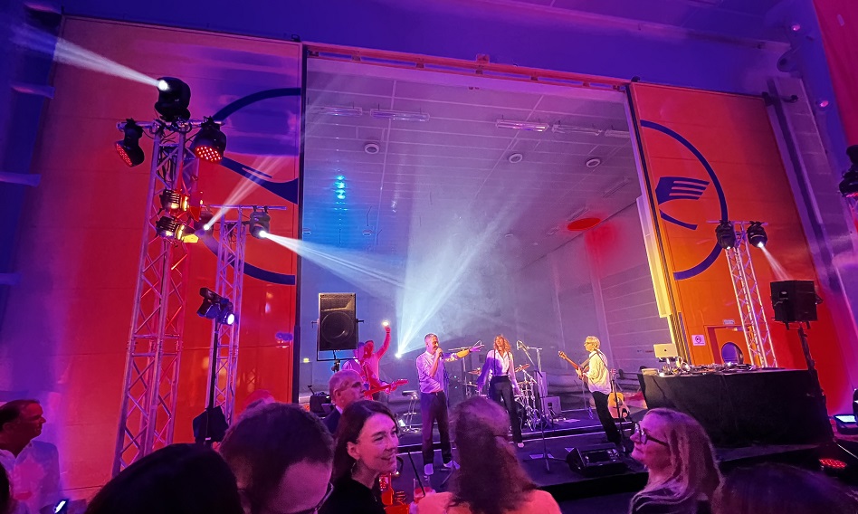 A band is playing; there are people in the foreground.