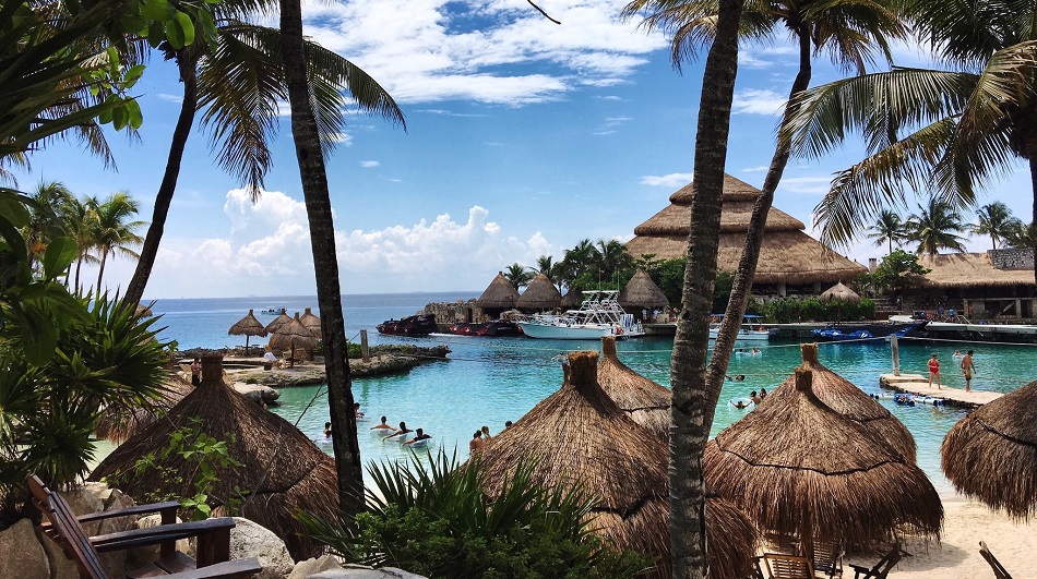 A beach with the sea and straw umbrellas.