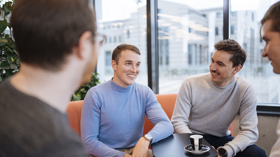 Drei personen sitzen an einem Tisch und unterhalten sich über Finanzierungsoptionen für die Pilotenausbildung.