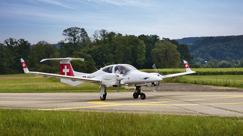 A view from the window of a SWISS airline airplane as it is taking off.